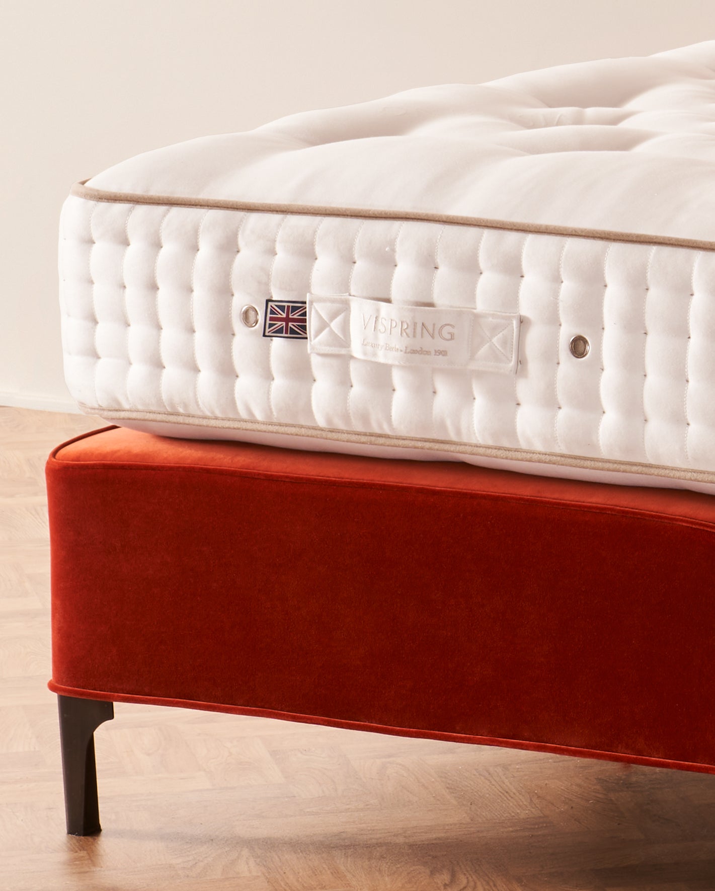 A Vispring Signatory mattress on a rust velvet divan base