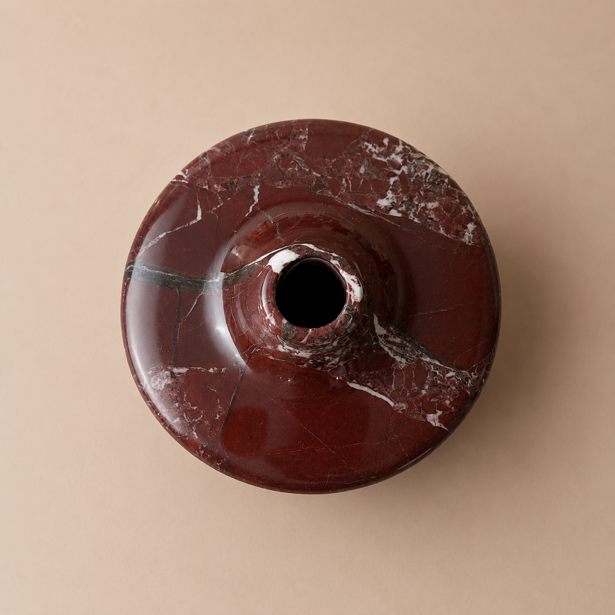 Maroon marble-patterned object on a beige background