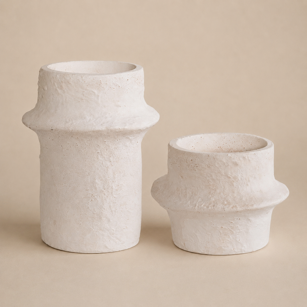 Two white textured vases on a beige background