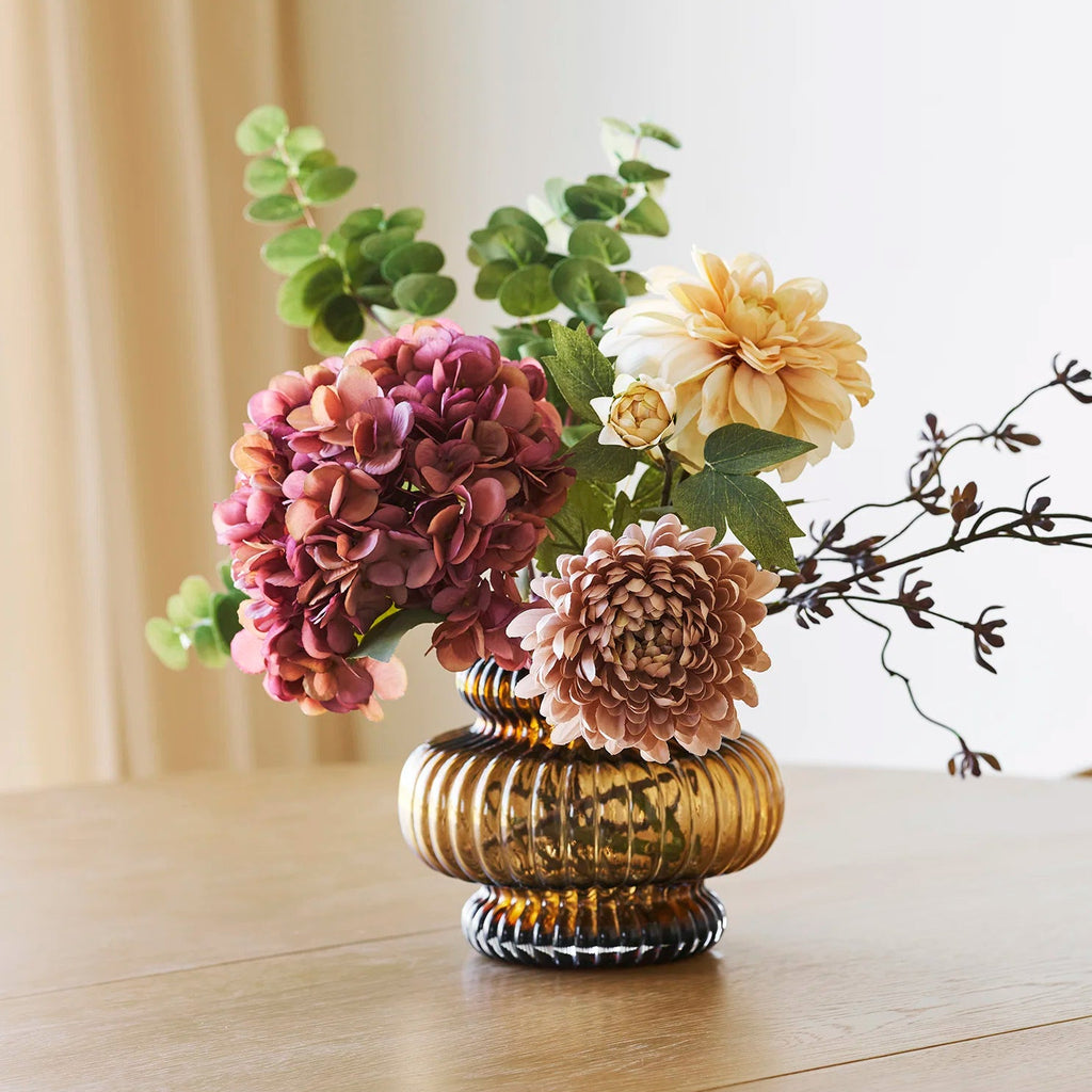 Decorative vase with flowers on a wooden surface