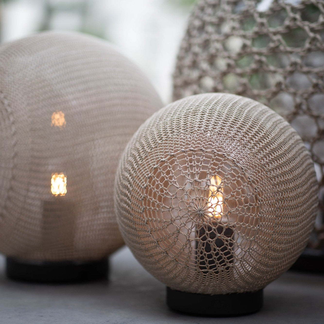 Two spherical textured lamps with a warm glow on a blurred background