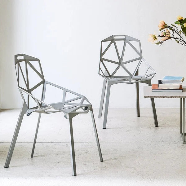 Modern chairs and a table with decor items on a light wooden floor.