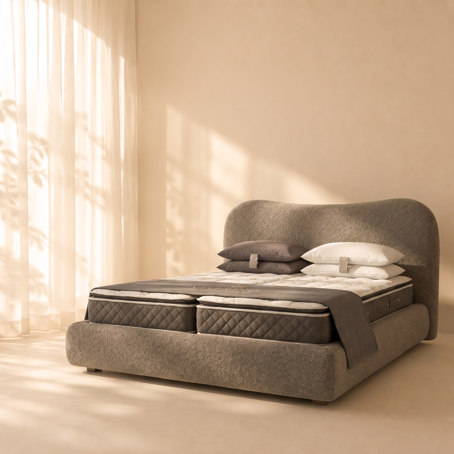 Gray upholstered bed with white pillows in a softly lit room.
