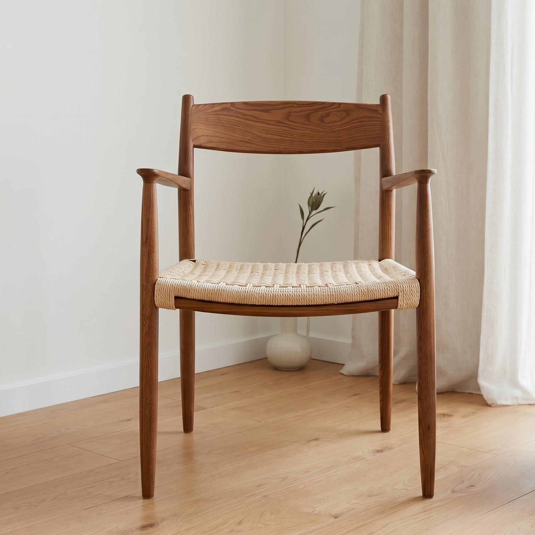 Wooden chair with woven seat in a room with light-colored walls and curtains.