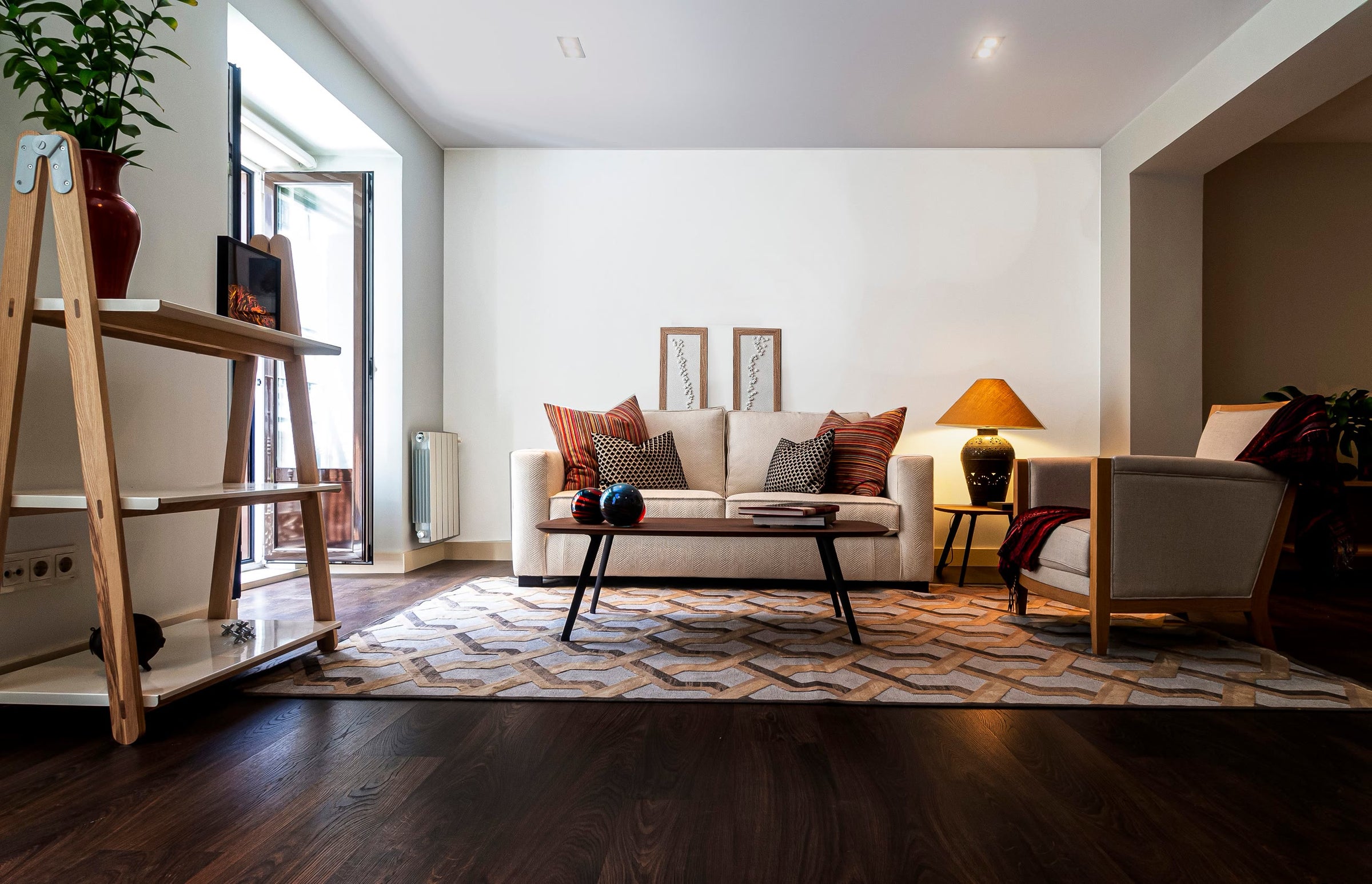 A bright living room with a low sofa and open garden doors