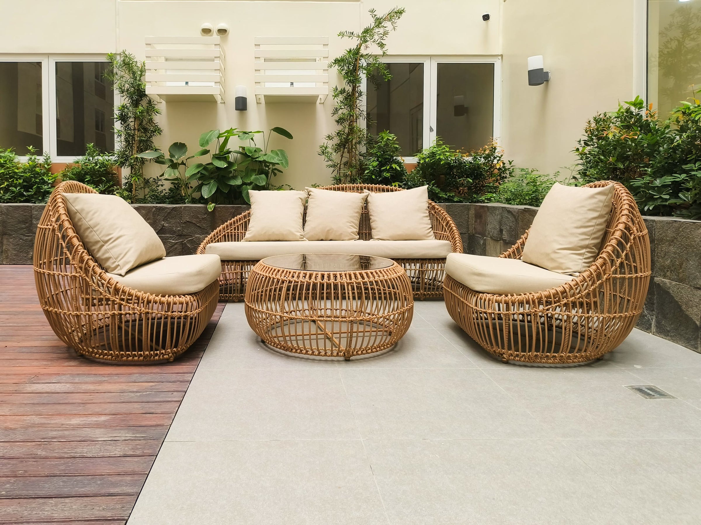 Woven rattan lounge chairs on a stone terrace