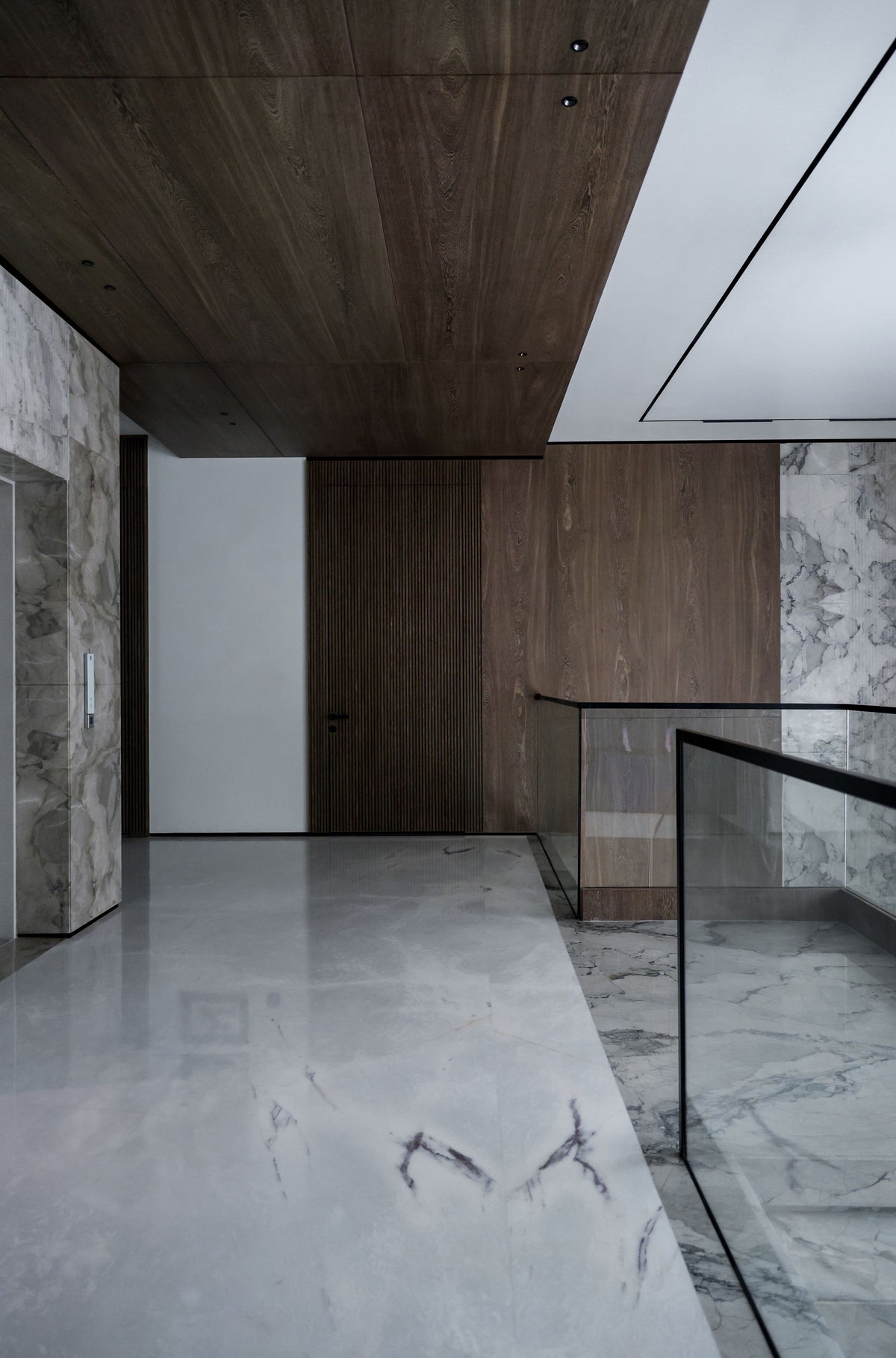 An interior of marble and walnut panelling in low daylight