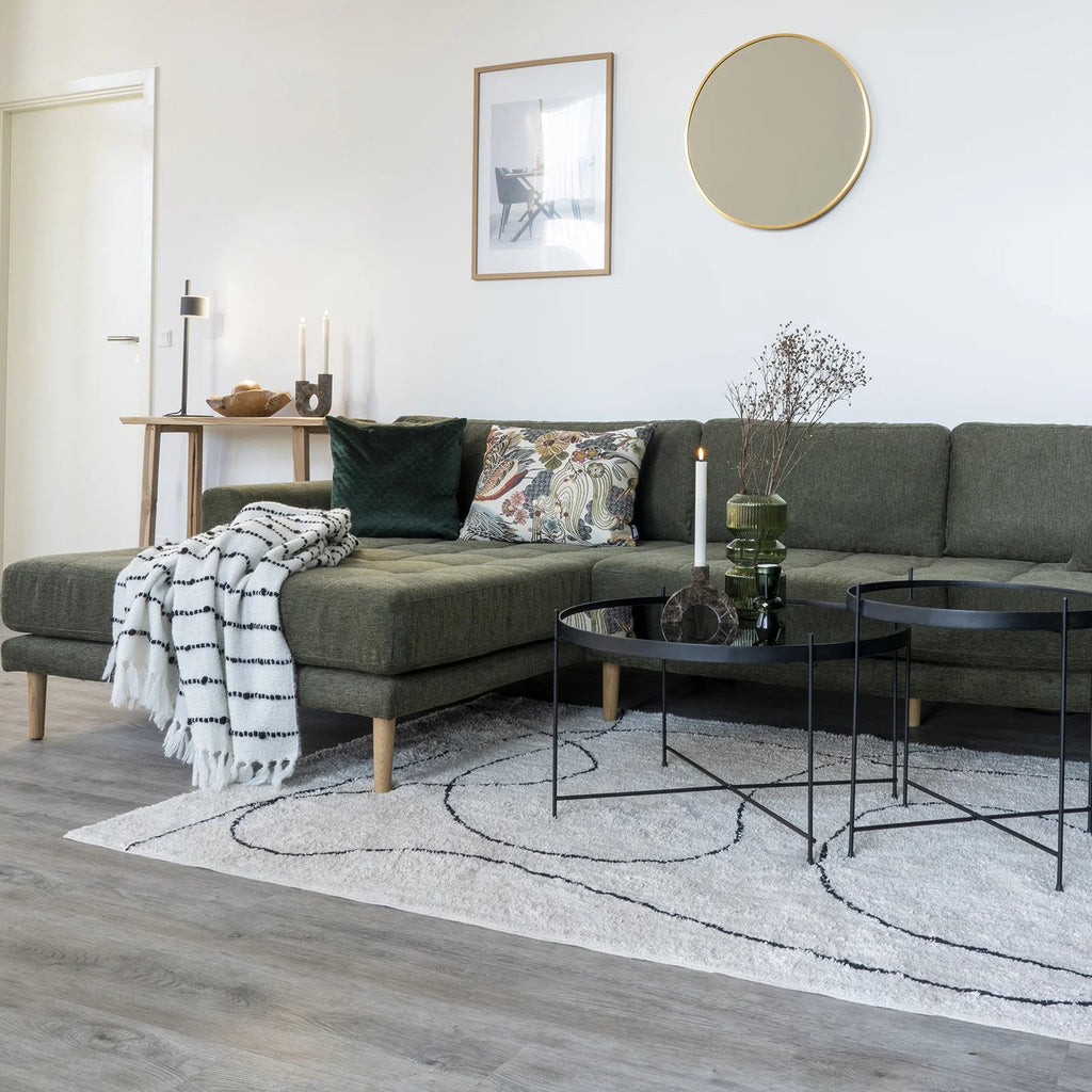 Modern living room with gray sofa, coffee table, and decorative items.